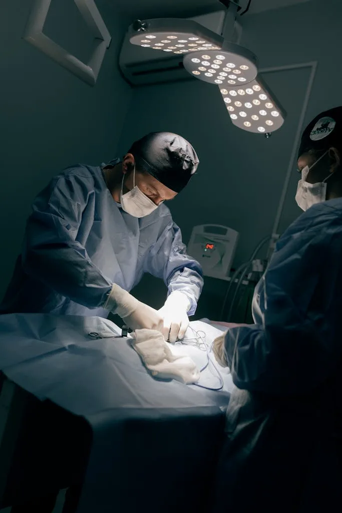Medical team in operating room performing surgery under professional lighting.
